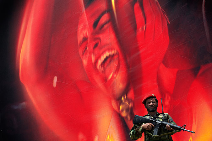 Solider standing in front of a painting during Afghan Independence Day.