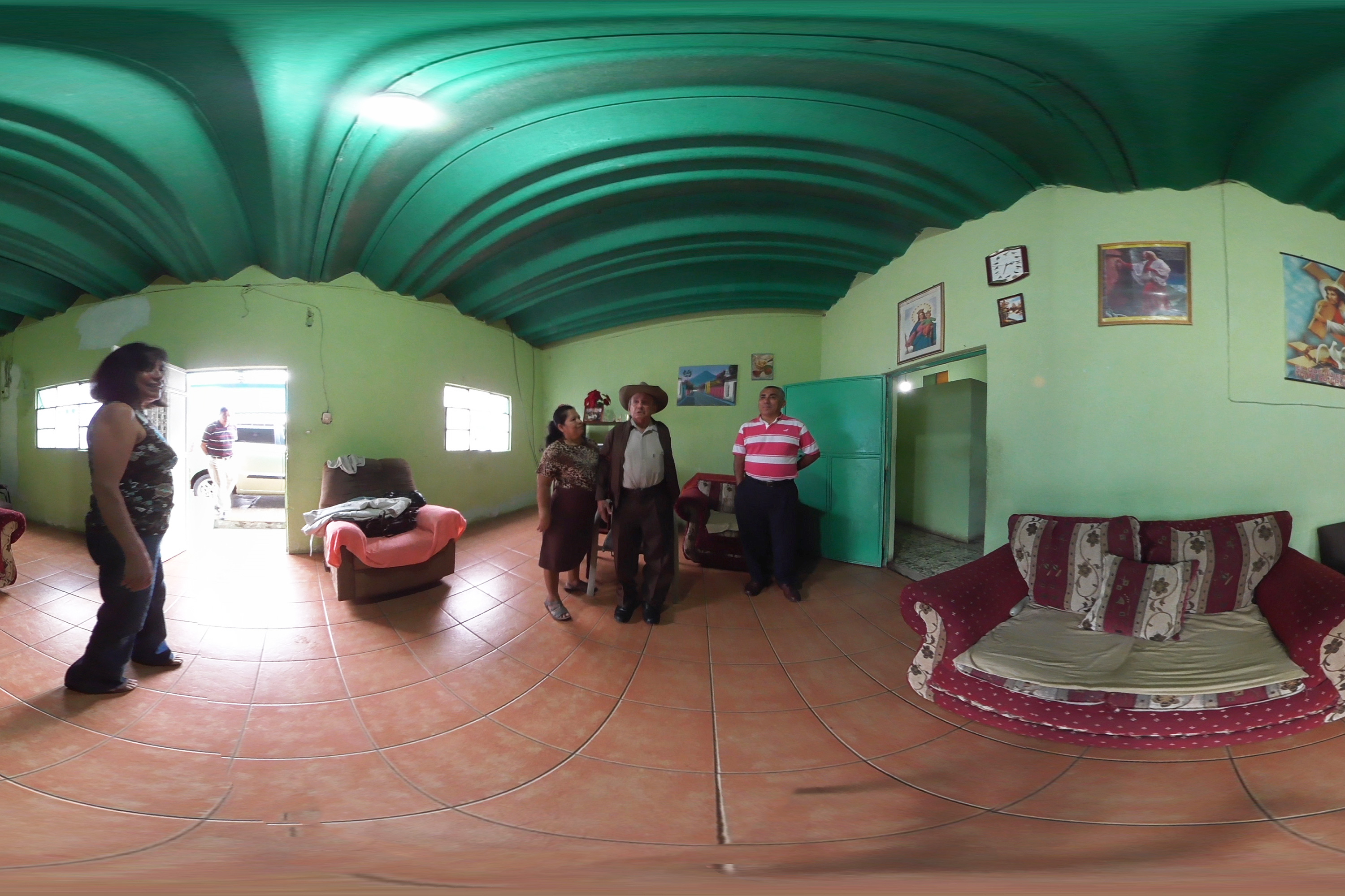 A distorted 360 degree video still of a family in a green room