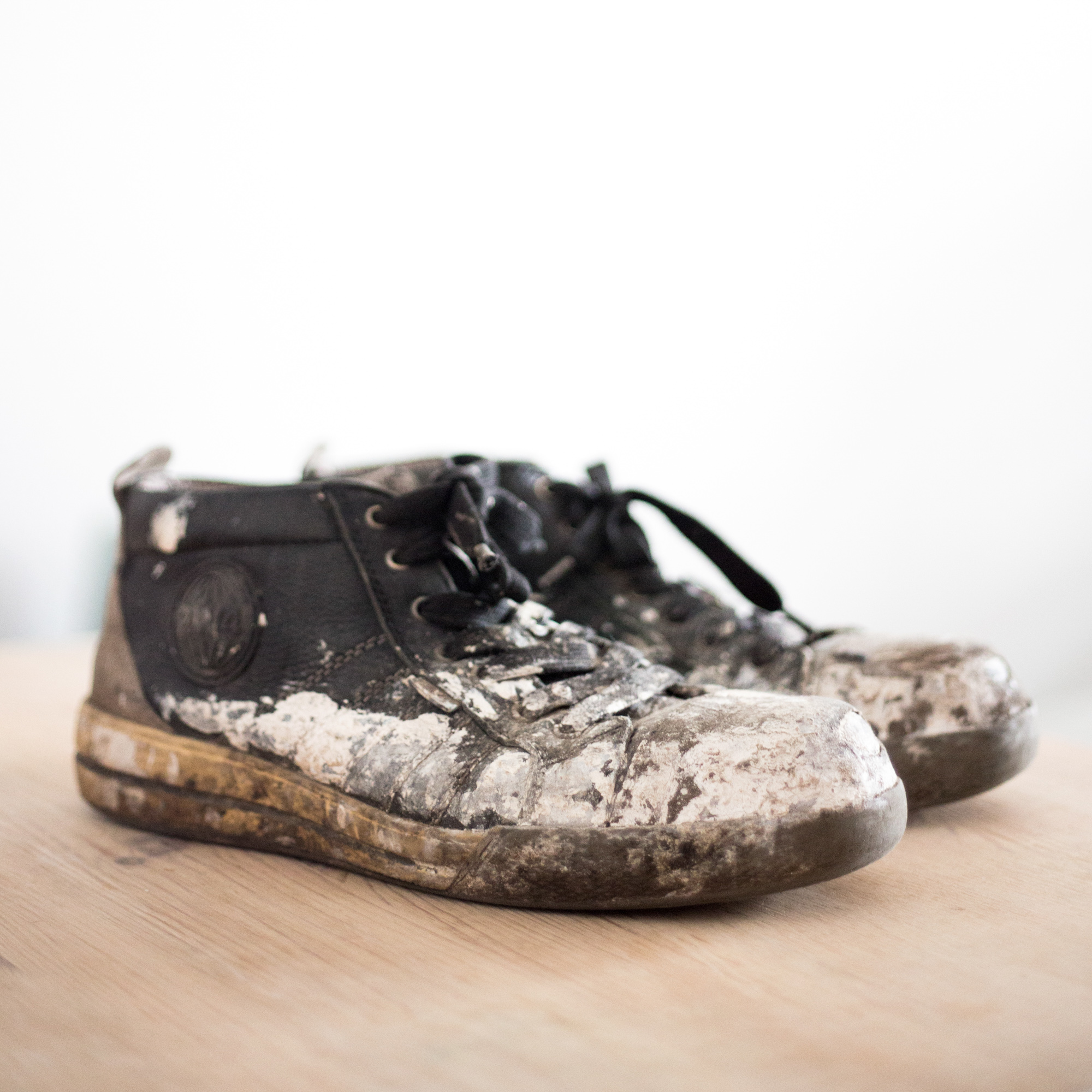A pair of worn work boots on a table