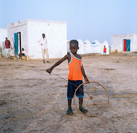 Boy holding rusty bike wheel