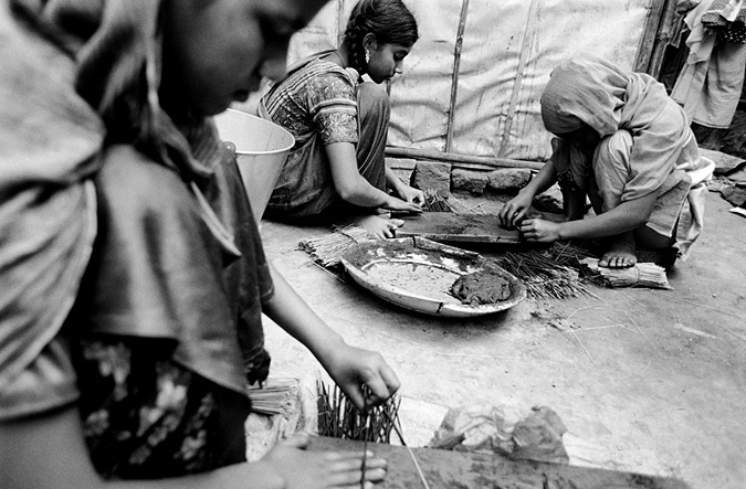 Girls making charcoal sticks
