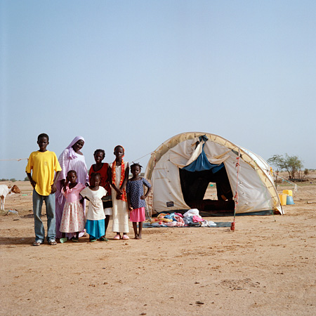 Family in desert standing in front of tent