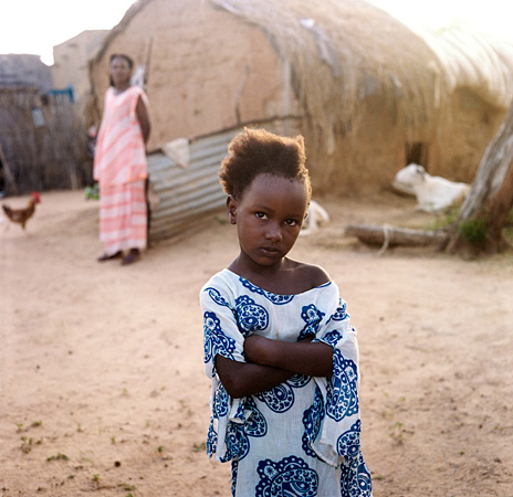 Girl standing in front of hut