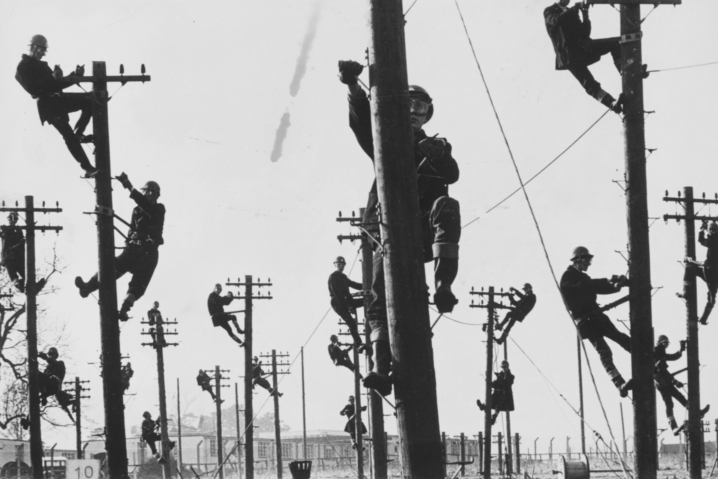 Men scaling telephone poles
