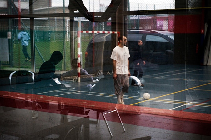 Window reflection of people practicing soccer