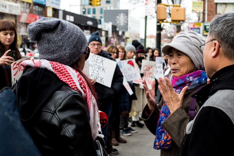 People gather on a city sidewalk