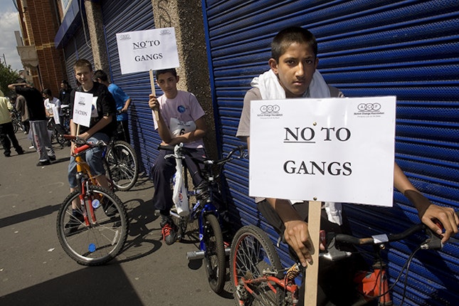 Boys on bikes holding signs