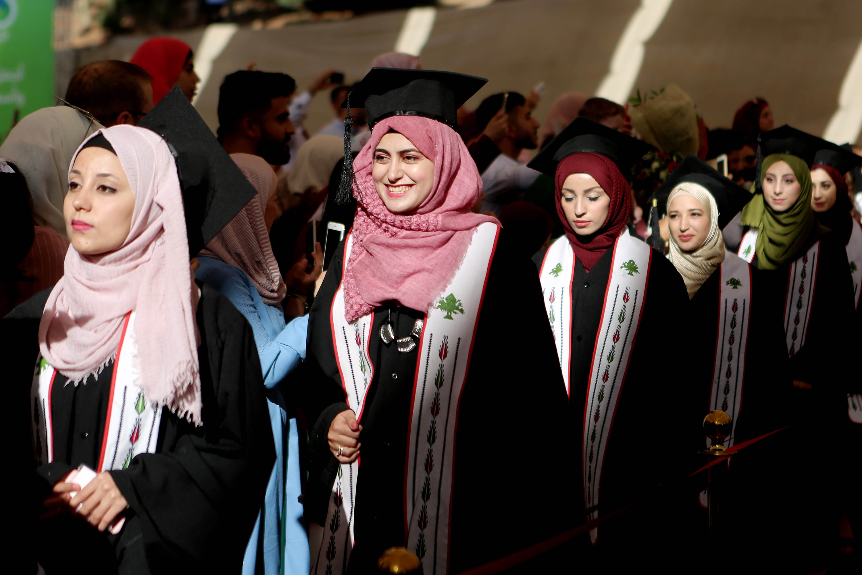 A line of women in graduation caps and gowns.