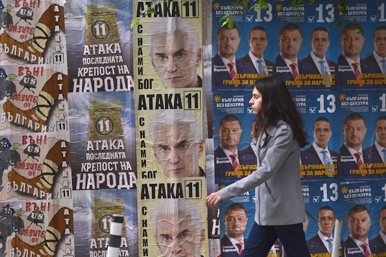 woman walking past election posters