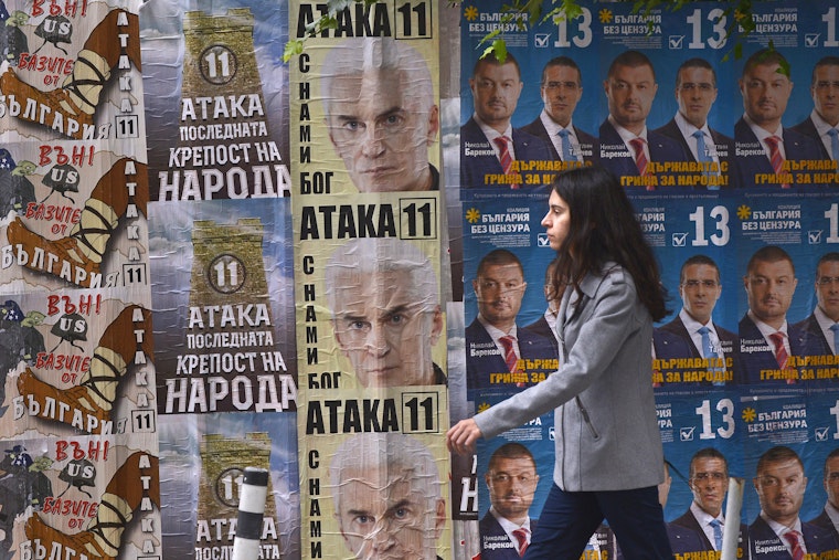 A woman walks past election posters for the ultra-nationalist Ataka party in Sofia, Bulgaria, in October 2014. Photo credit: © Nikolay Doychinov/Getty woman walking past election posters