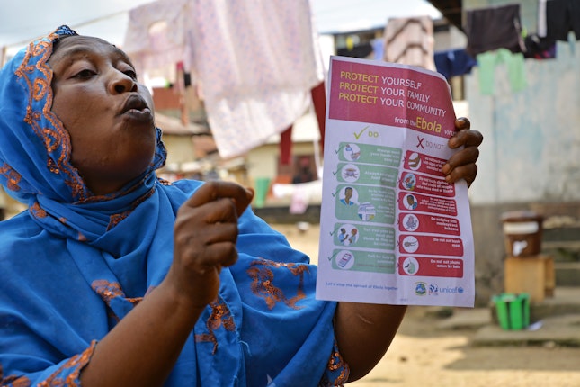 A women teaching Ebola protection