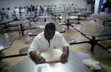 An inmate reading a book at a table