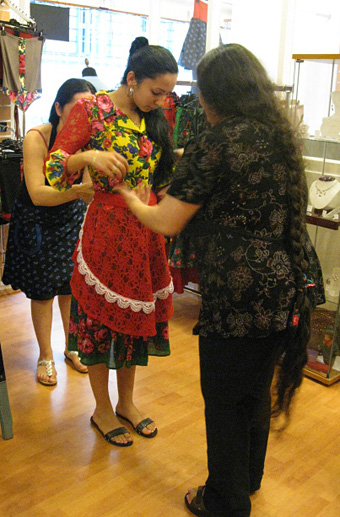 Member of music group Karavan Familia trying on costume
