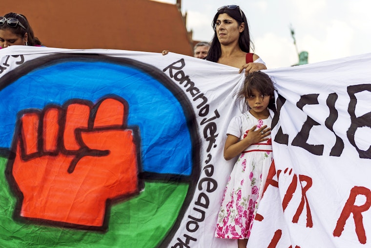 A young girl in front of a painted banner