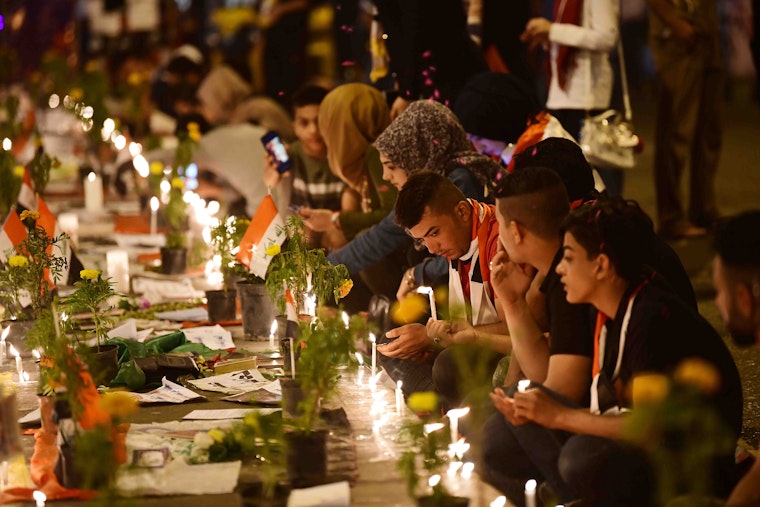 Rows of people and candles at a vigil