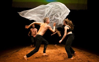 Four performers around a floating sheet