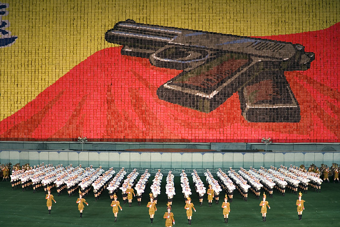 Marchers in front of large image of pistol