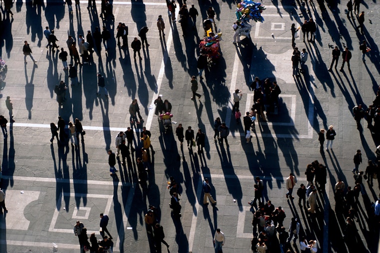 Shadows and people in an open square