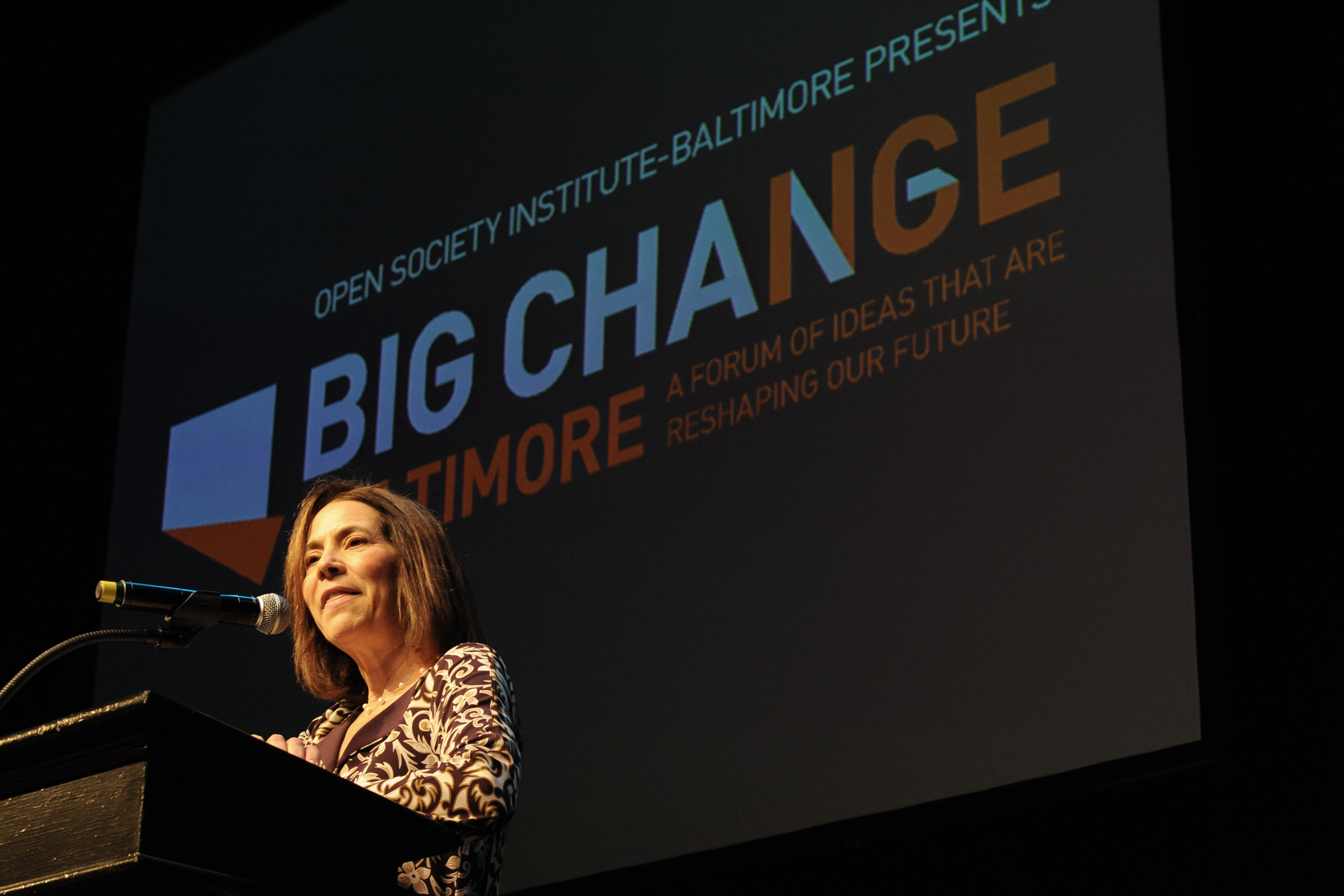Diane Morris speaking at a podium on a stage.