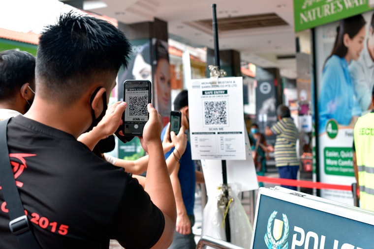 A man scans a QR code at a shopping mall as part of a digital contact tracing program, in Singapore, on May 16, 2020. Photo credit: © YK Chan/AP Photo A man scans a QR code at a shopping mall