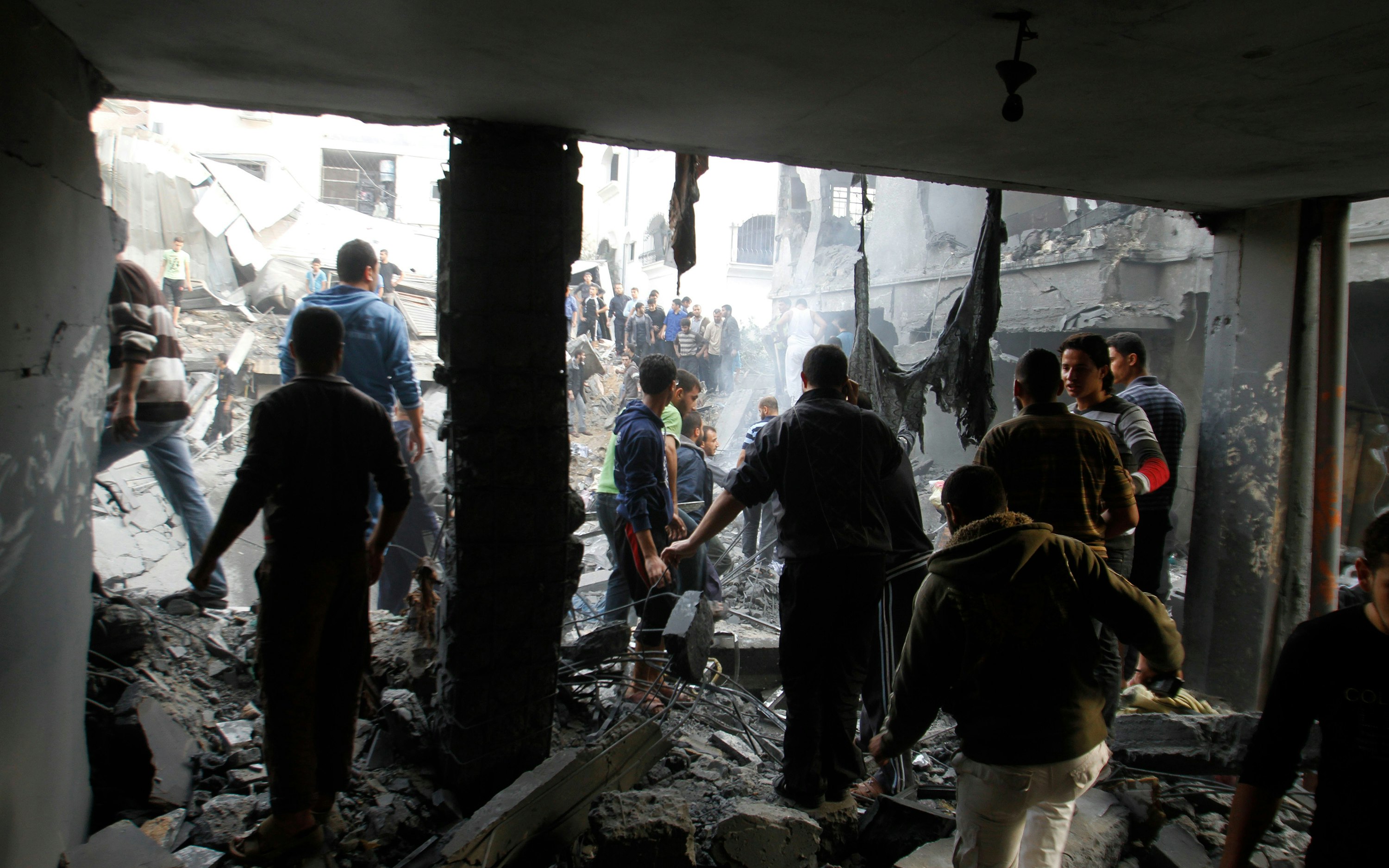 People walking among rubble of a destroyed building