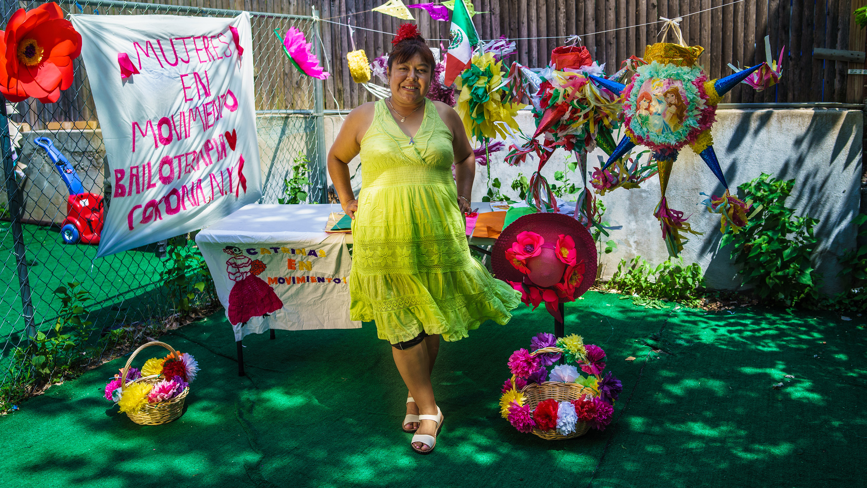 A woman in a yellow dress standing in front of a table