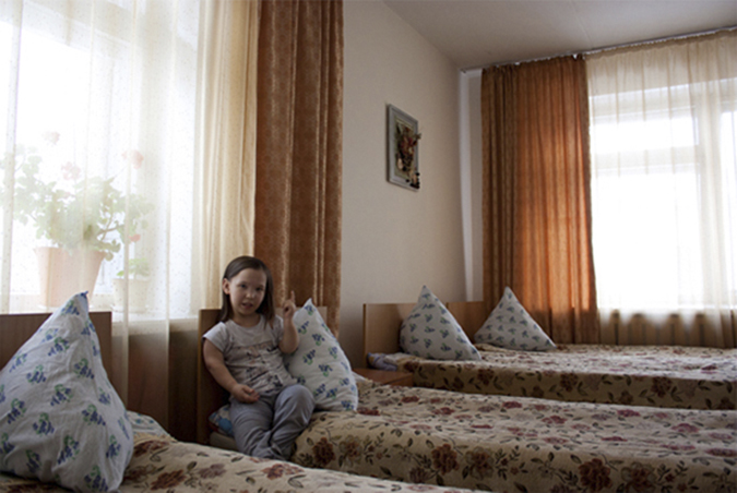 Young girl sitting on bed.