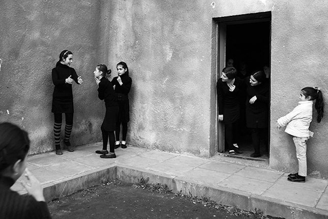 Girls playing outside a building.