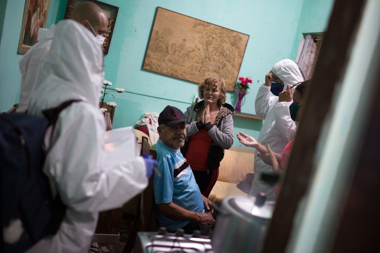 Nurses examine a man in his home for symptoms of COVID-19, in São Paulo, Brazil, on April 19, 2020. Photo credit: © Andre Lucas/picture alliance/Getty Nurses examine a man in his home
