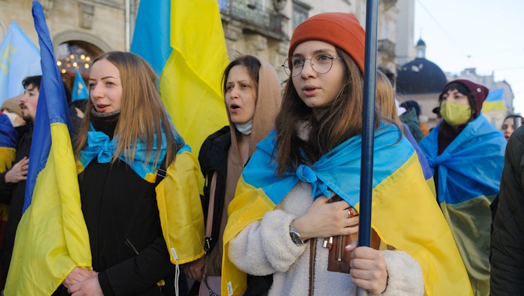 A group of people wearing and holding the Ukrainian flag
