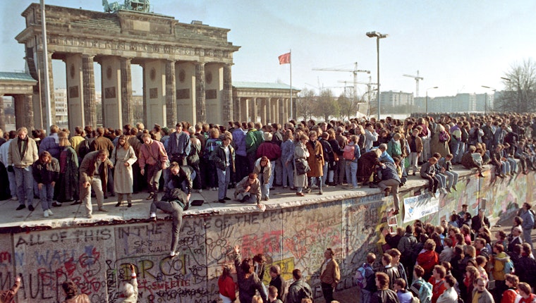 Crowds of people on and around the Berlin Wall