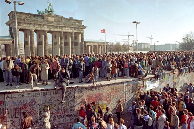 Crowds of people on and around the Berlin Wall