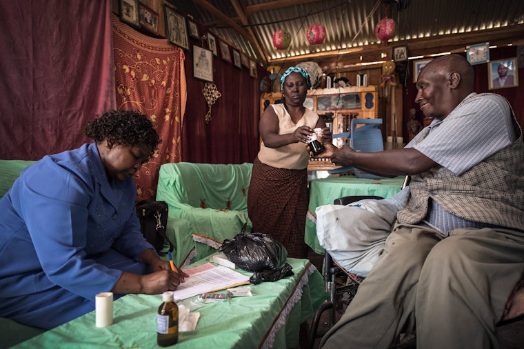 A palliative care nurse and legal aid worker with Nyeri Hospice visits a cancer patient to provide pain killers and provide psychosocial support in Kenya, on May 17, 2013. © Sven Torfinn/Panos for the Open Society Foundations A nurse distributes medicine to an elderly man
