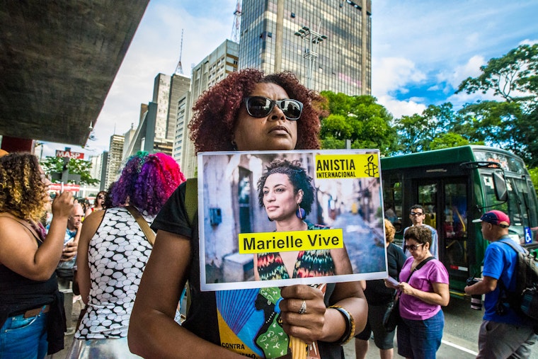 A woman holds aloft a sign with a picture of the slain activist and elected official Marielle Franco in São Paulo, Brazil.