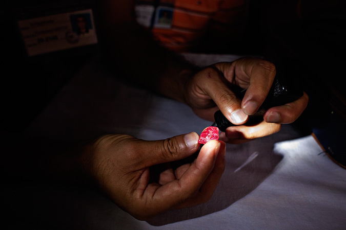 Hands holding an uncut ruby