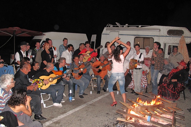 A group of people playing musical instrument and a woman dancing