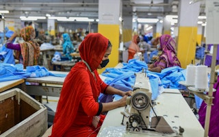 A woman at a sewing machine in a factory