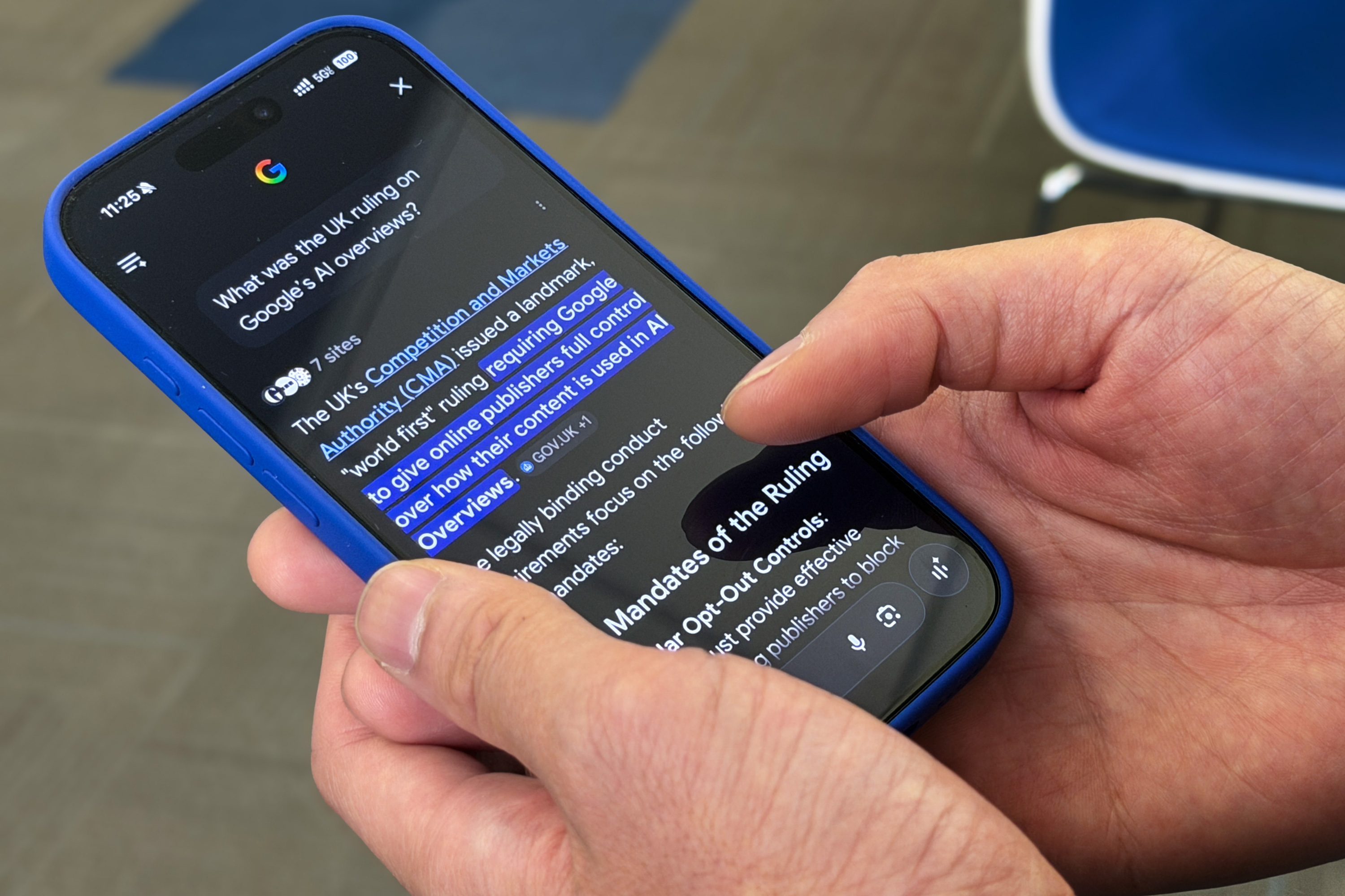 Person holding a phone with the screen showing a Google AI Overview