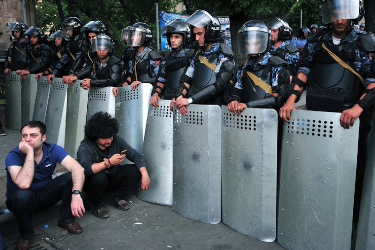 Demonstrators sit in front of a line of riot police during a protest in Yerevan, Armenia, on June 24, 2015. Photo credit: © Karen Minasyan/AFP/Getty A line of police holding shields