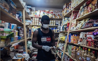 A vendor counts out Nigerian banknotes in a shop