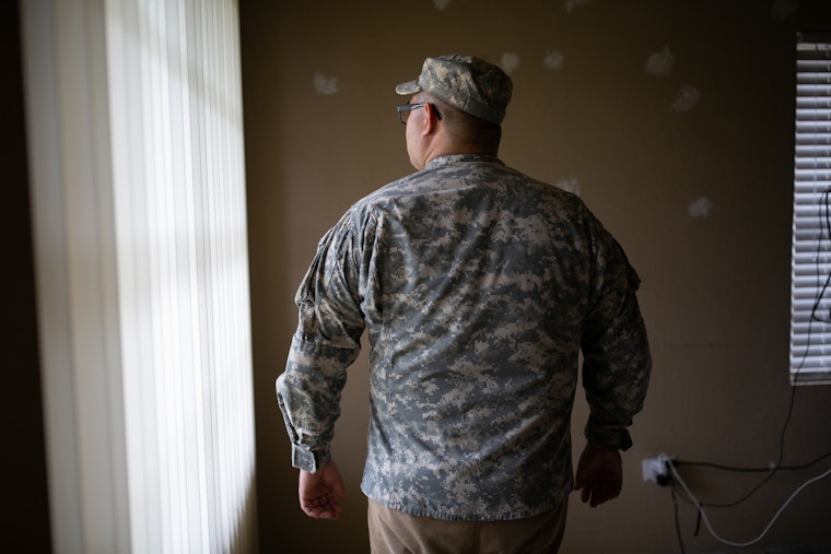 A man in a military uniform facing away from the camera