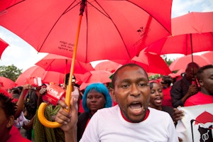 Demonstrators holding red umbrellas