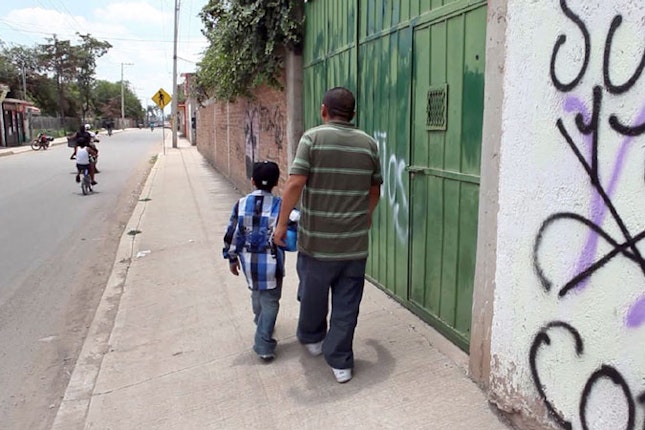 Father and son walking down a street