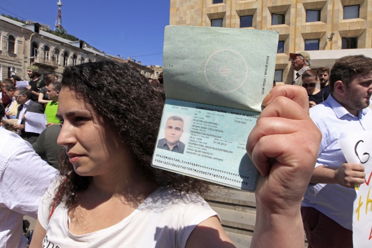 A woman holding up a passport