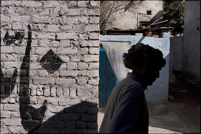 Woman walking by brick wall