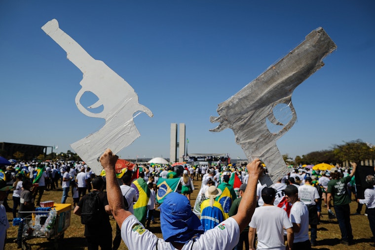 A man holding two cardboard guns