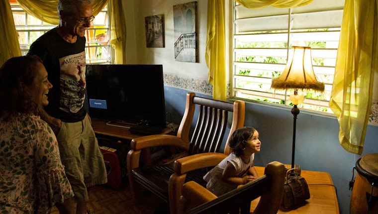 A family reacts when a lamp turns on in their home after receiving power for the first time in 11 months in Ponce, Puerto Rico, on August 14, 2018. Photo credit: © Erika P. Rodriguez/The New York Times/Redux A family looking at a lamp
