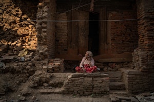 A woman sitting surrounded by bricks