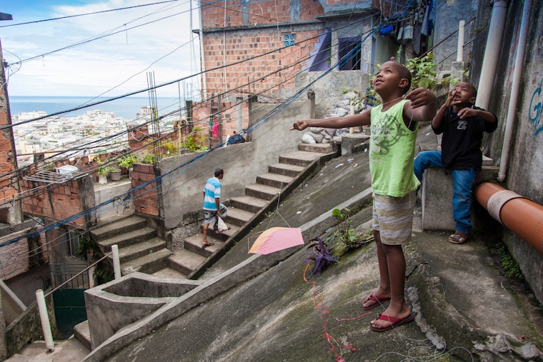 Children fly a kite in the hillside favela of Pavão-Pavãozinho in Rio de Janeiro on May 19, 2013. Photo credit: © Hans-Bernhard Huber/Laif/Redux Children standing on pavement