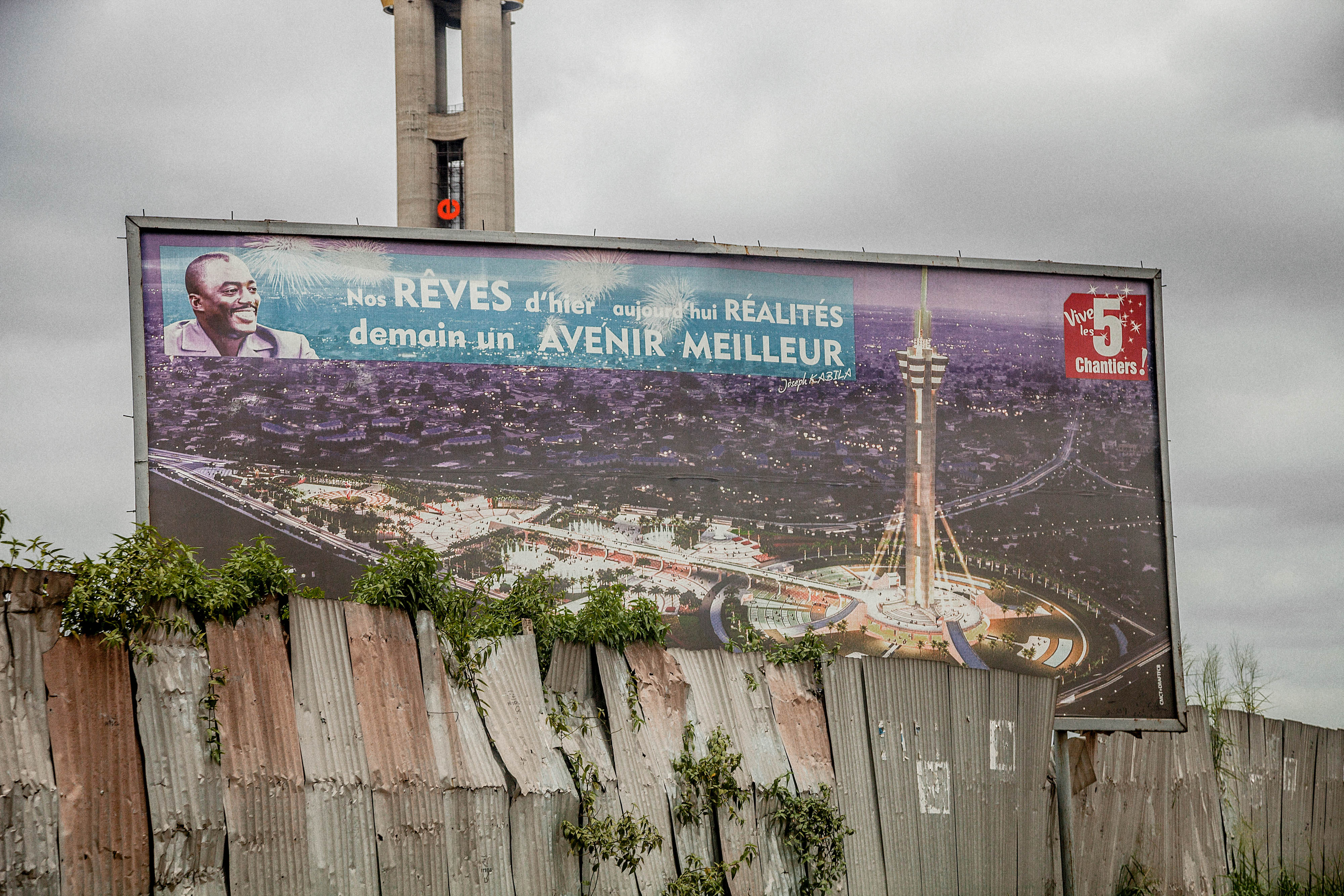 A billboard cutting across a aluminum fence